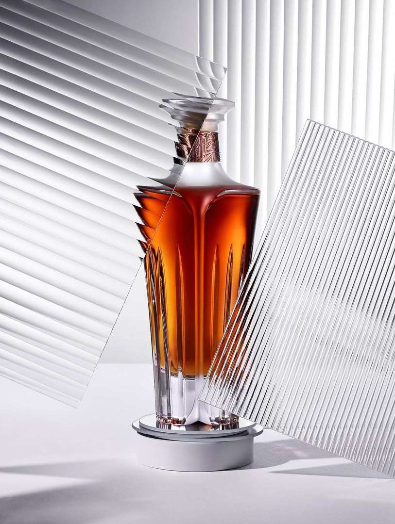 Elegant liquor bottle on a rotating platform, featuring clear textured glass panels and soft studio lighting against a white backdrop.