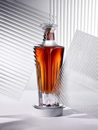 Elegant liquor bottle on a rotating platform, featuring clear textured glass panels and soft studio lighting against a white backdrop.