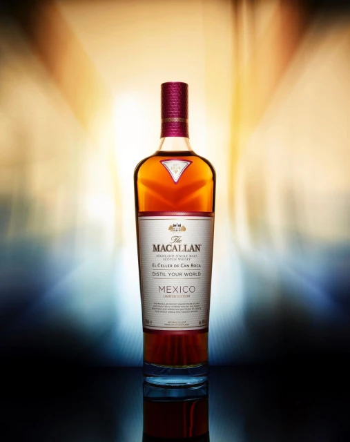 Macallan whiskey bottle on a reflective surface with a blurred yellow and blue background, product shot for Food & Beverage.