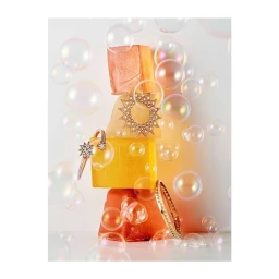 Stacked colorful translucent blocks holding fine diamond jewelry surrounded by floating soap bubbles on a white background