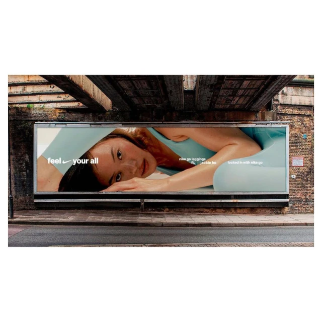 Nike ad on an urban billboard: woman in activewear, angled pose, close-up, natural light, promoting Nike Go leggings with Jackie H.