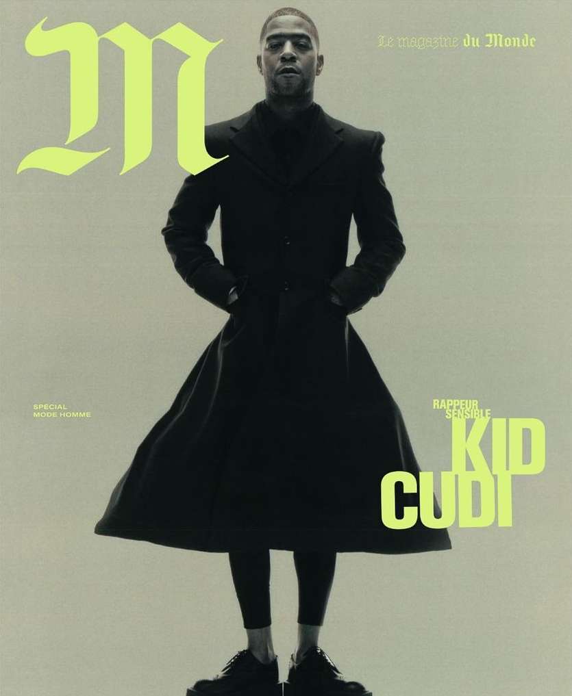 Magazine cover featuring Kid Cudi in a black coat and boots, standing against a light background with neon green text accents.