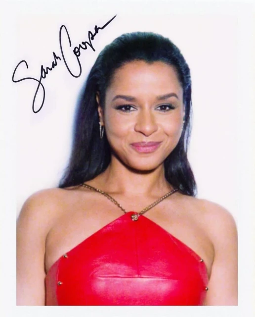 Portrait of Sarah Cooper in a red dress against a white background, featuring her signature prominently displayed on the image.