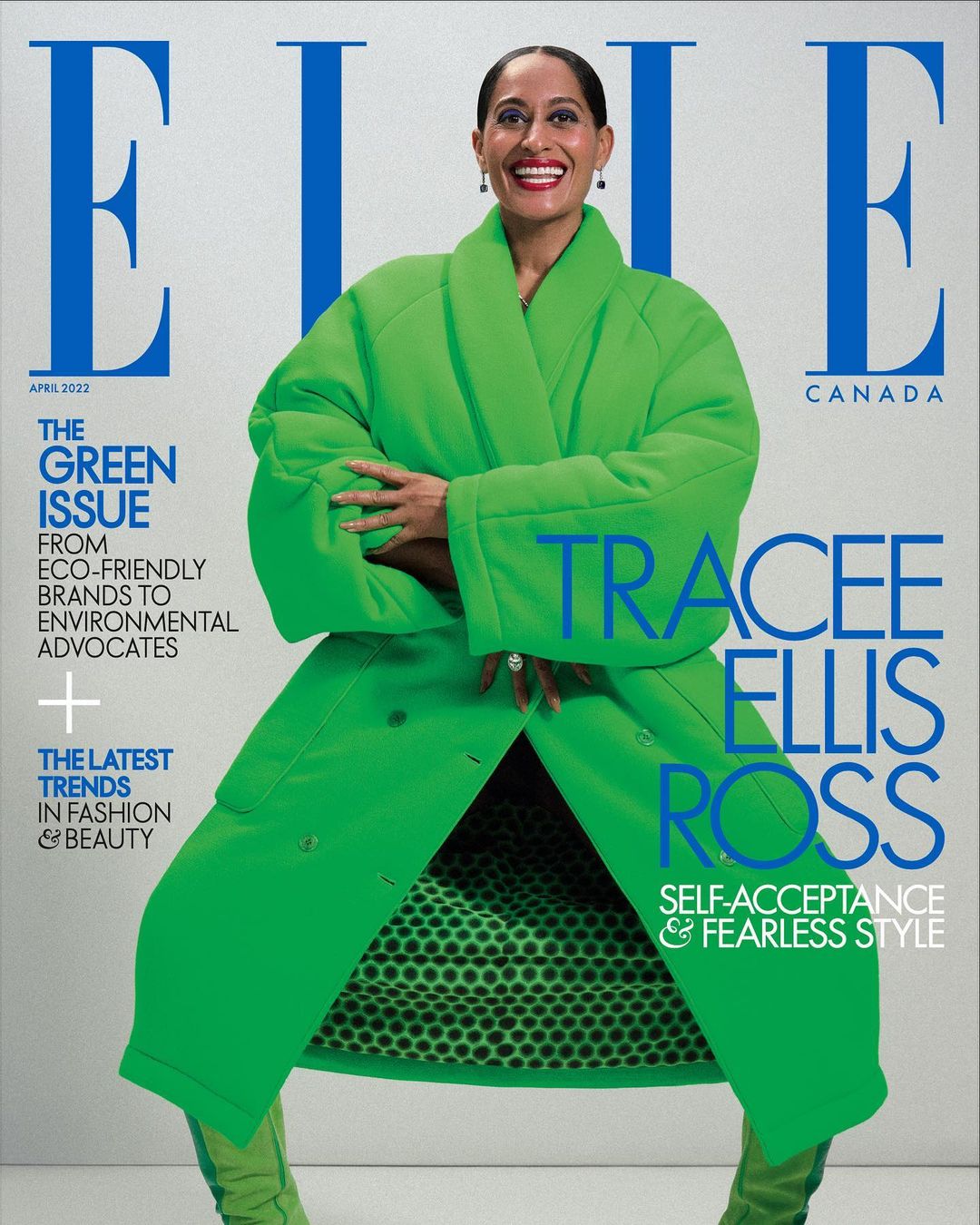 Tracee Ellis Ross on the cover of Elle Canada, April 2022, wearing a bright green coat and boots with a polka dot lining against a white background.