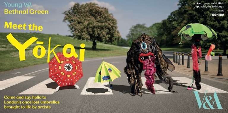 Colorful umbrella art installation, "Yokai," on a pedestrian crossing against a background of trees and green space, promoting a museum exhibit.