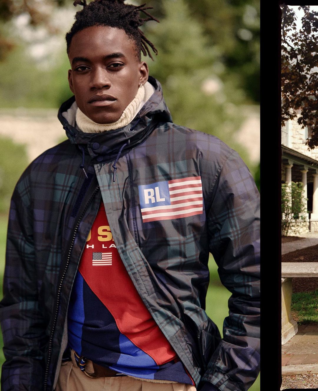 An African-American man models a blue plaid Ralph Lauren jacket with a US flag patch in a natural outdoor setting with a stone structure.