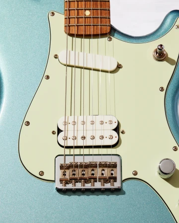 Close-up of a light blue electric guitar with white pick-ups, strings, and gold hardware on a white background. Musical instrument.