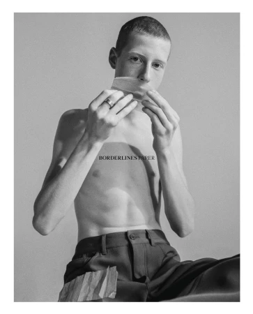 Portrait of a shirtless man with short hair holding a strip of tape over his mouth by Emma Picq