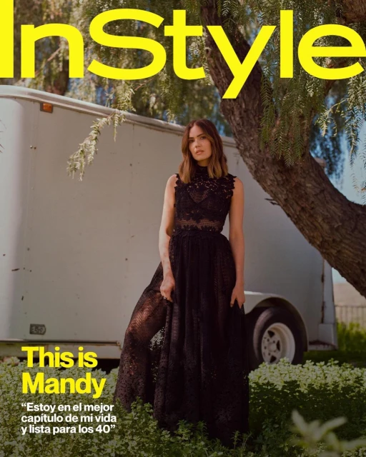 Magazine cover featuring Mandy Moore in a black lace dress, posing outdoors with a trailer and foliage in the background.