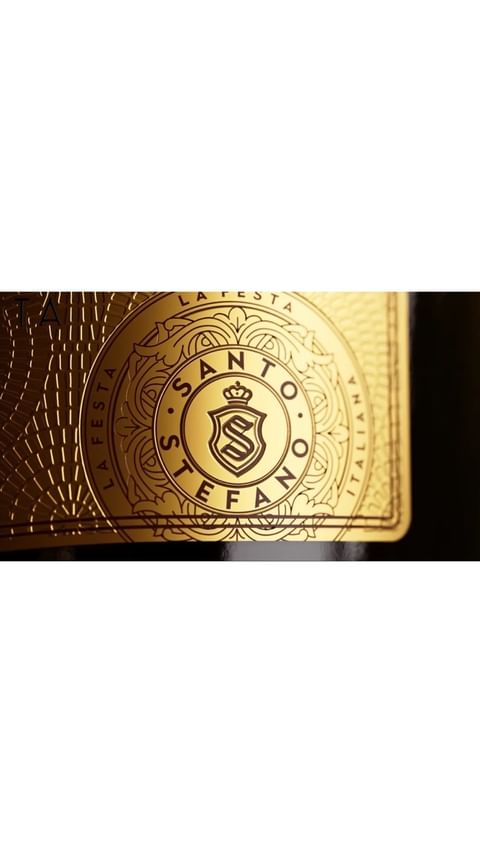 Close-up of a gold wine label with the words Santo Stefano and a stylized crown above an 'S' inside a shield.