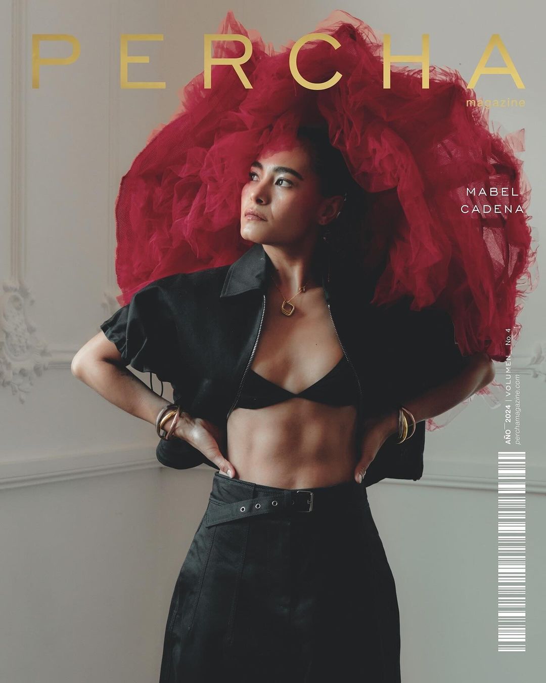 Magazine cover shot of woman with a red tulle headpiece, black top and skirt. Gold text reads 'Percha'.
