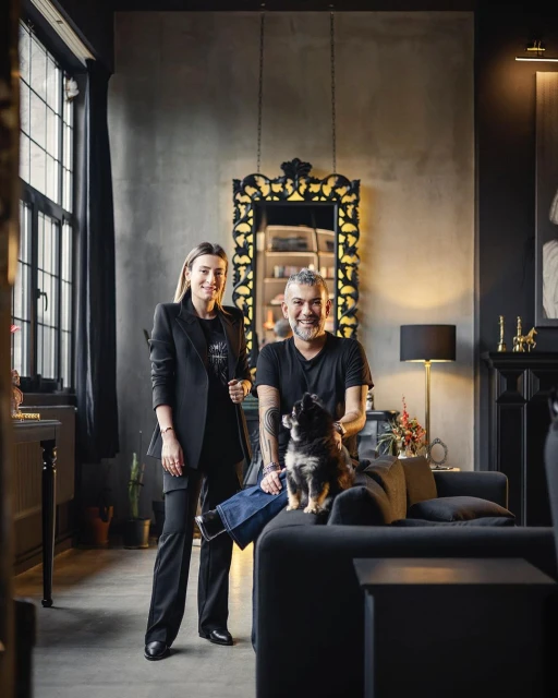 Couple and dog pose in upscale home interior featuring modern decor, neutral color palette, and elegant architectural details.