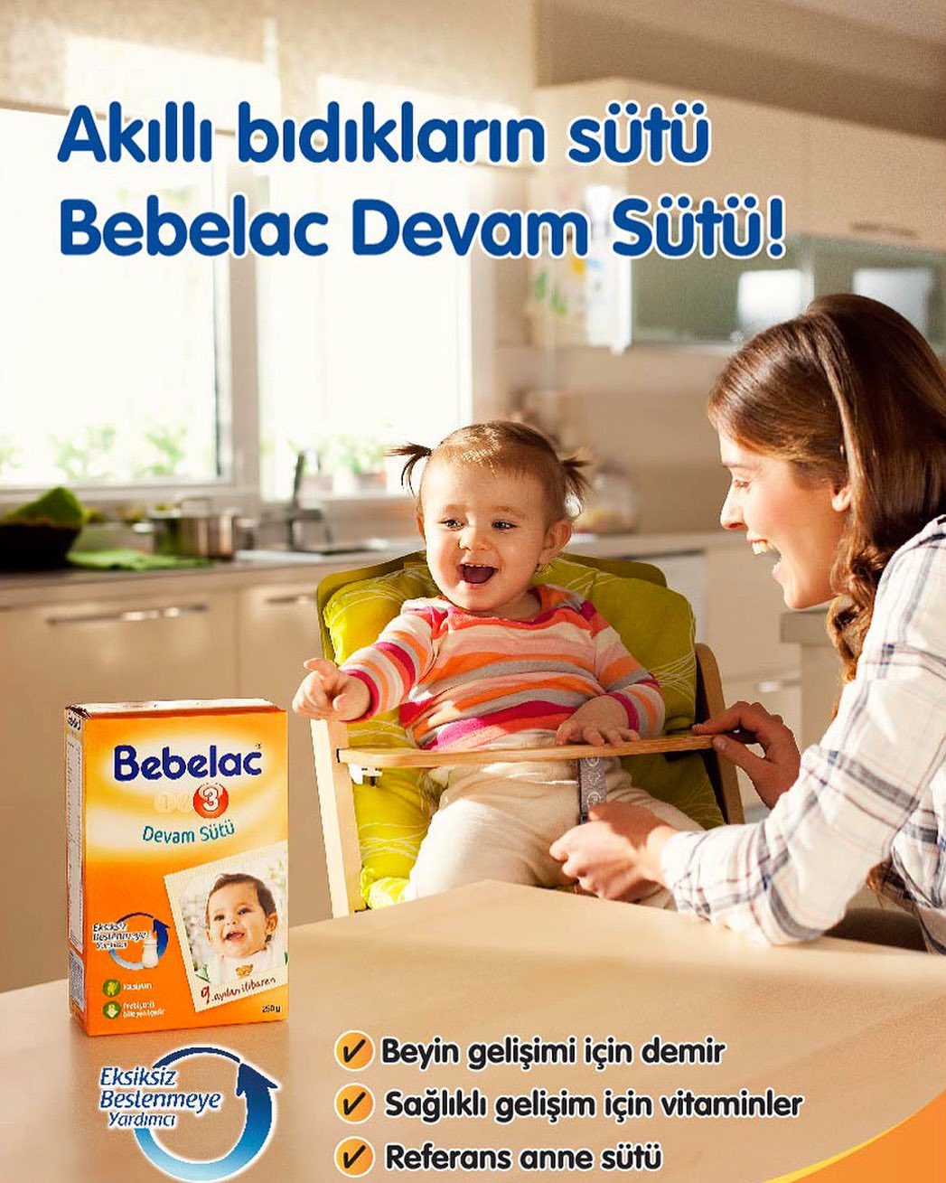 Smiling baby seated in a highchair with an adult female, next to a box of Bebelac infant formula on a table indoors.