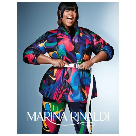 Fashion-forward plus-size model in a colorful puffer jacket and leggings strikes a pose against a light blue gradient backdrop.