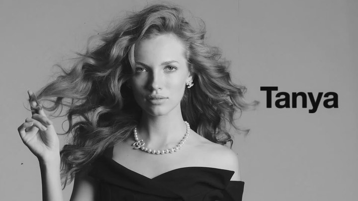 Black and white portrait of an adult woman with flowing hair, wearing a necklace and off-the-shoulder dress, with the name 'Tanya' visible.