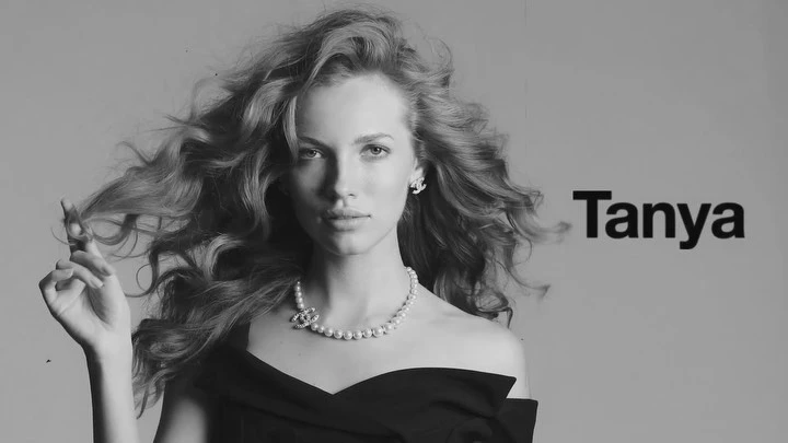 Black and white portrait of an adult woman with flowing hair, wearing a necklace and off-the-shoulder dress, with the name 'Tanya' visible.