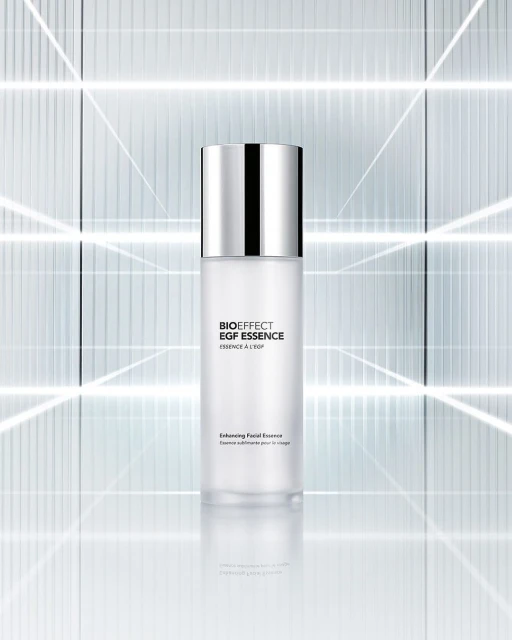 Bioeffect EGF Essence bottle stands out with its minimalist design, featuring a silver cap, set against a geometric backdrop.