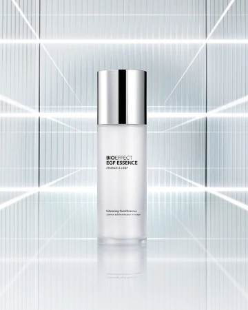 Bioeffect EGF Essence bottle stands out with its minimalist design, featuring a silver cap, set against a geometric backdrop.