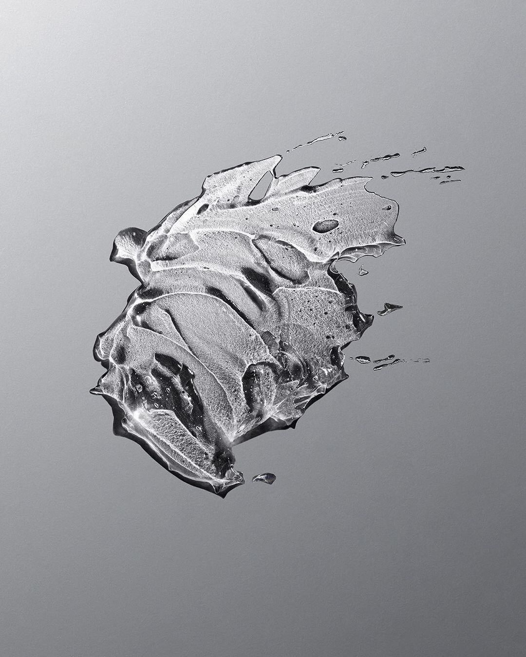 Abstract close-up of a clear gel substance with curved lines and textures on a gray gradient background, product shot, beauty concept.