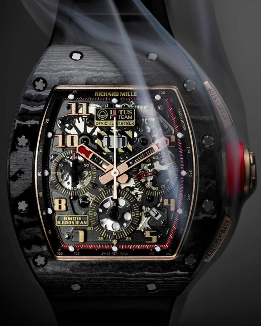 Luxury carbon fiber Richard Mille RM011 R. Grosjean wristwatch close-up, featuring an intricate skeleton dial, red accents, and smoke overlay.