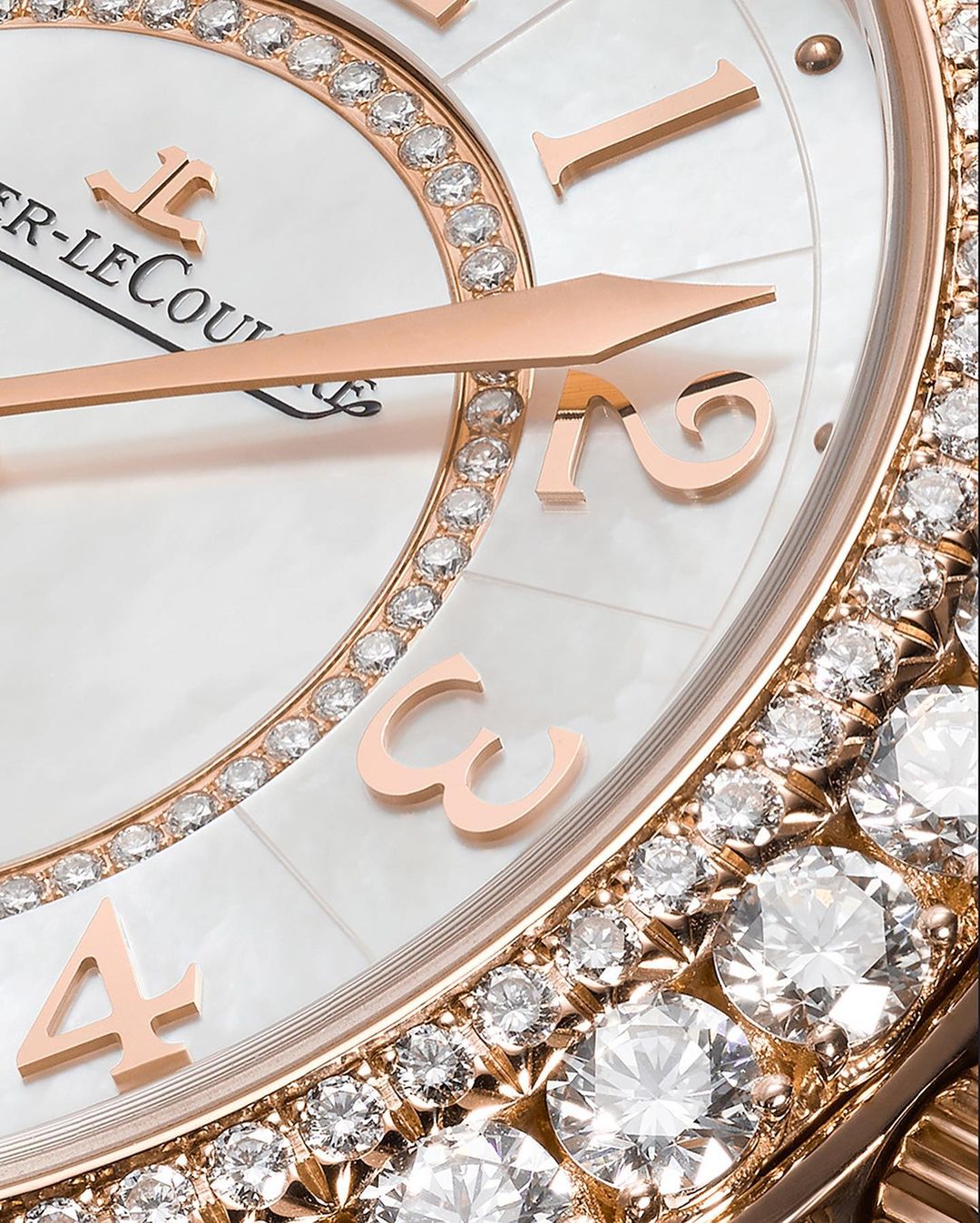 Close-up of a luxurious watch with rose gold hands and diamond embellishments against a white mother-of-pearl face.