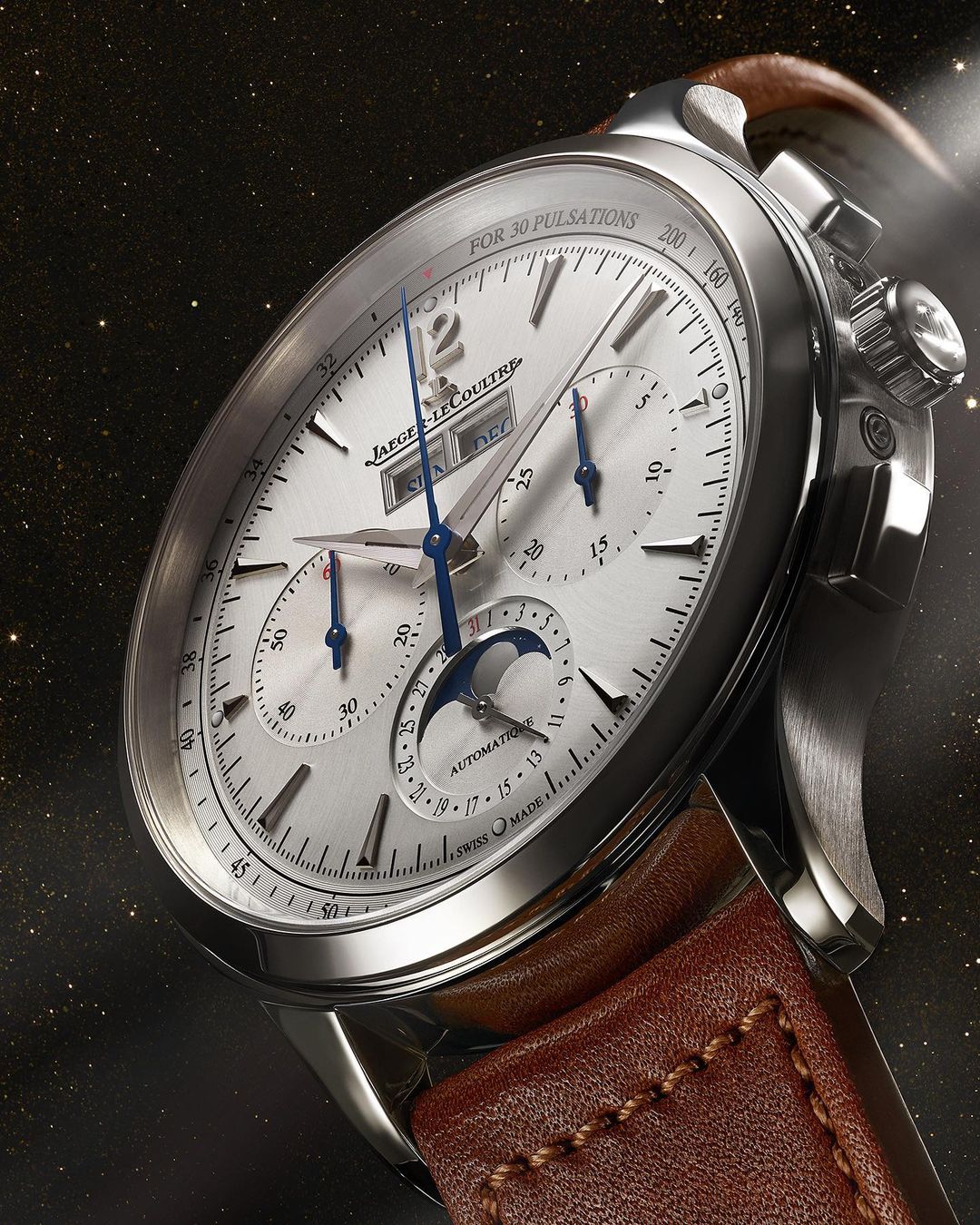 Silver Jaeger-LeCoultre wristwatch featuring a brown leather strap and white face, close-up shot on dark background with stars.