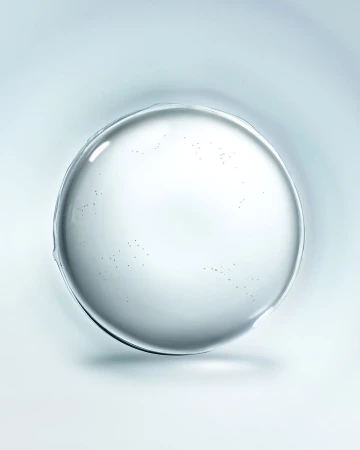 A clear, round droplet or gel sits against a soft, light blue gradient background, highlighted by a central reflection point.