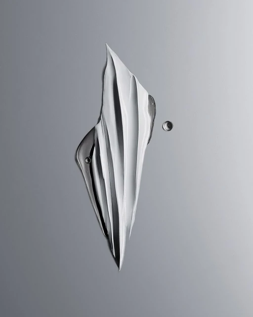 Abstract image of white skincare cream swatch with small water droplets on a gradient grey background in studio lighting.