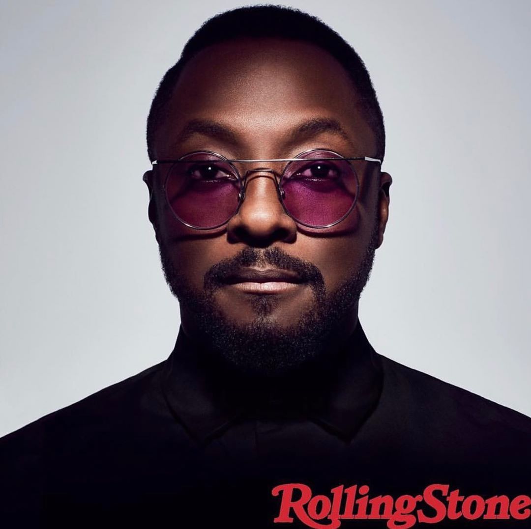 Close-up studio portrait of Will.i.am with glasses in black turtleneck, against a grey background with a Rolling Stone magazine logo.