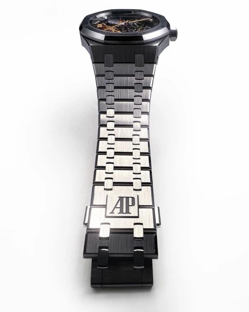 Close-up of a black and silver Audemars Piguet Royal Oak watch with an open-worked dial, set against a clean, white background.