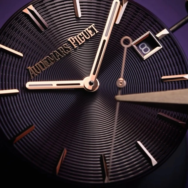 Close-up of a luxury Audemars Piguet wristwatch featuring a black textured dial, rose gold hands and hour markers, and date window.