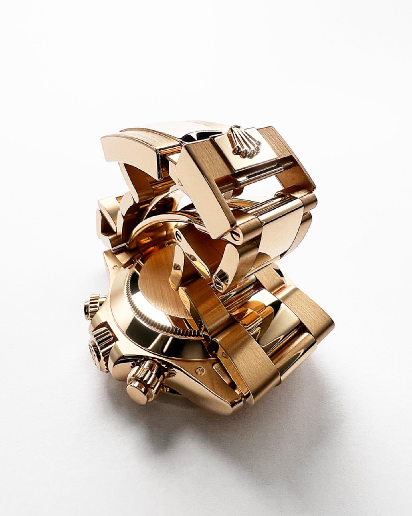 Close-up studio shot of a gold Rolex watch with a bracelet, on a white background, emphasizing its luxurious design and craftsmanship.