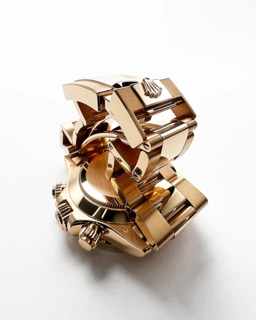 Close-up studio shot of a gold Rolex watch with a bracelet, on a white background, emphasizing its luxurious design and craftsmanship.
