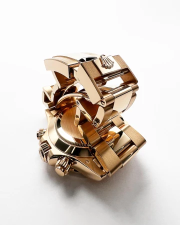 Close-up studio shot of a gold Rolex watch with a bracelet, on a white background, emphasizing its luxurious design and craftsmanship.