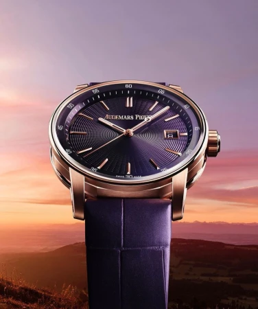 Close-up of a luxury Audemars Piguet watch with a purple face and gold casing, set against a blurred landscape backdrop.