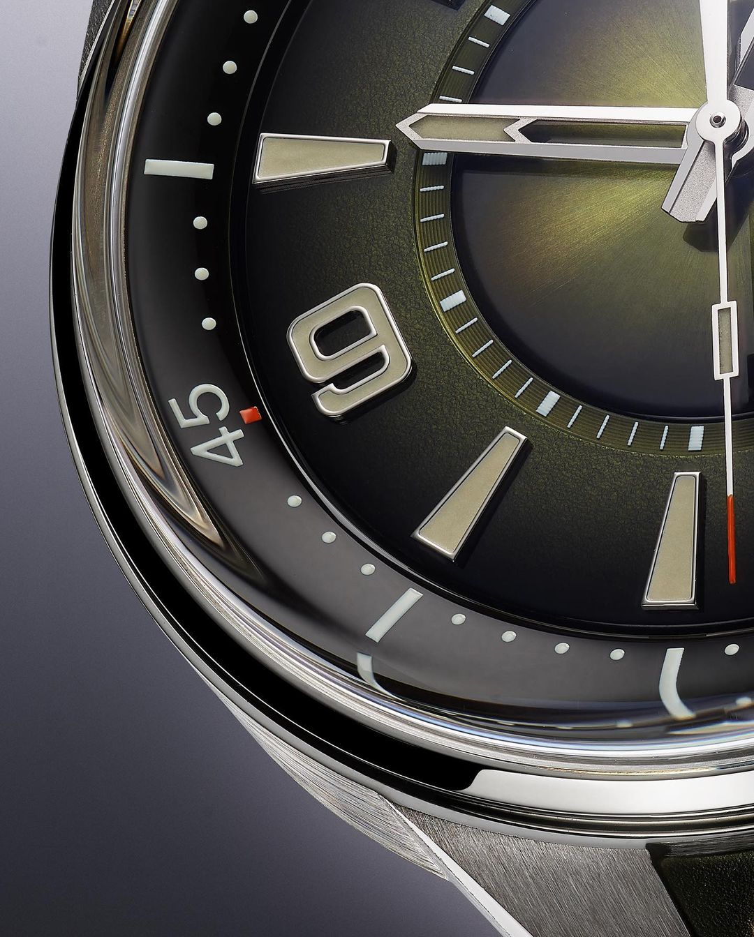 Close-up of a black-faced wristwatch with silver hands and markers. The time shows approximately 10:09. Silver casing and black strap are also visible.