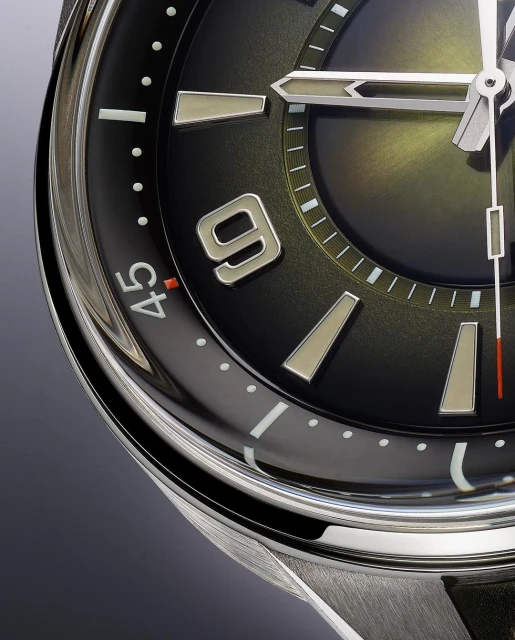 Close-up of a black-faced wristwatch with silver hands and markers. The time shows approximately 10:09. Silver casing and black strap are also visible.