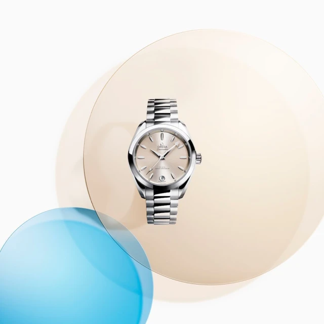 Silver Omega Seamaster Aqua Terra wristwatch with stainless steel bracelet against transparent peach and blue spheres on white.