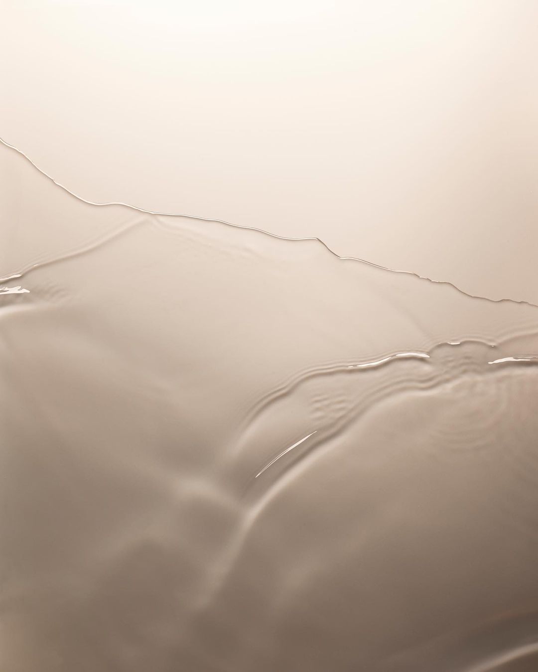 Abstract liquid art with waves and curves in shades of beige, cream, and white, creating a minimalist design with subtle textures.