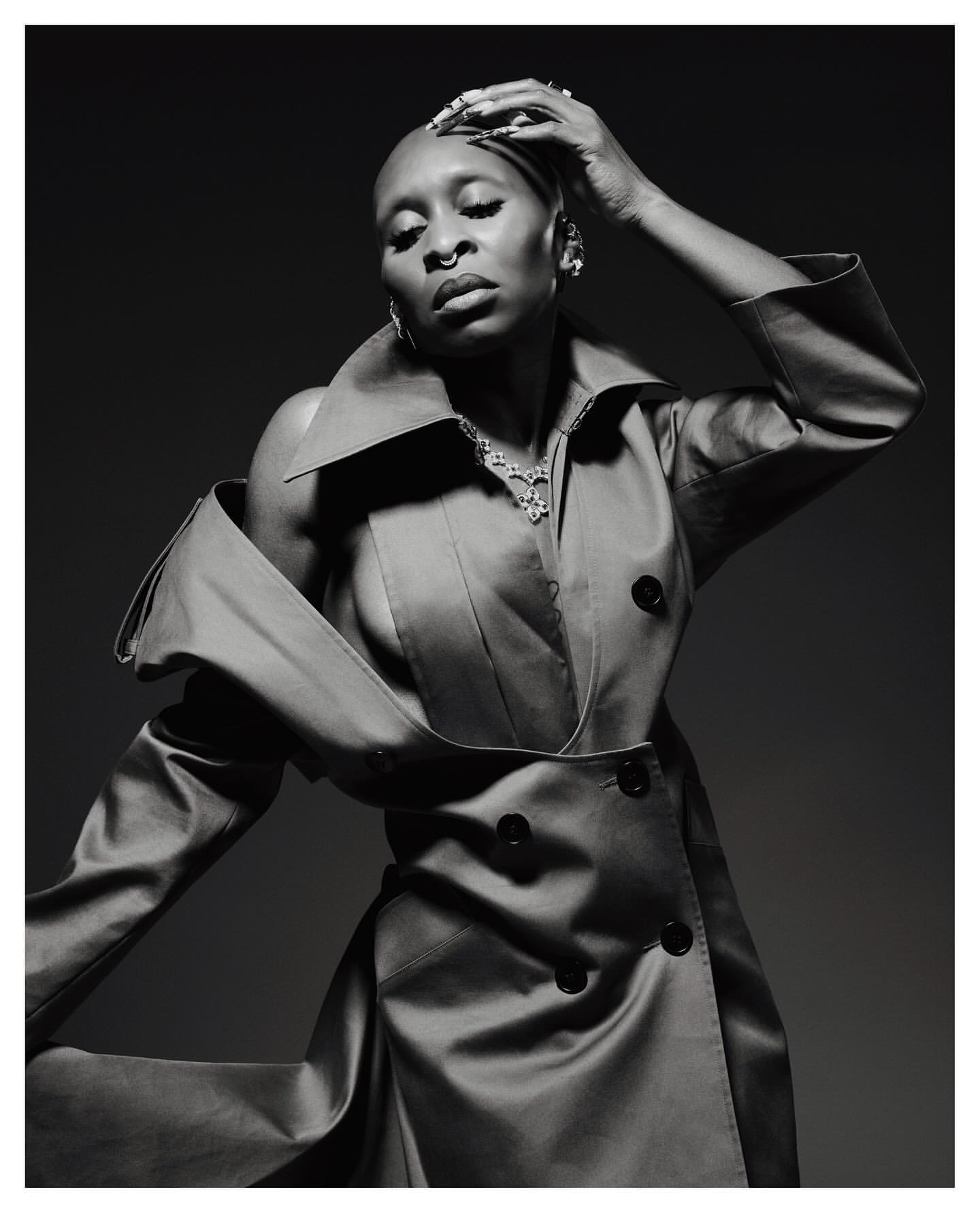 Portrait of a bald Black woman in an oversized trench coat posing by Erik Carter - Visie