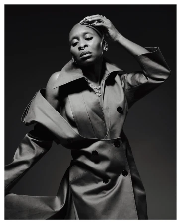 Portrait of a bald Black woman in an oversized trench coat posing by Erik Carter - Visie