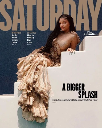 Magazine cover featuring a young woman in a long, ruffled dress sitting on white stairs against a dark blue background. The text reads 'Saturday'.