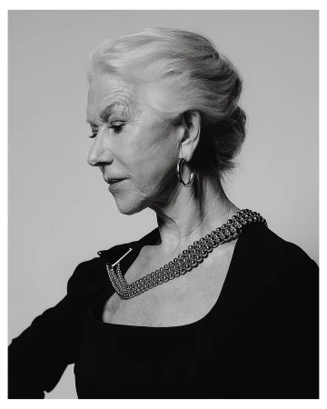 Monochrome portrait of Helen Mirren in profile wearing a dark top with a metallic beaded statement necklace and hoop earrings.
