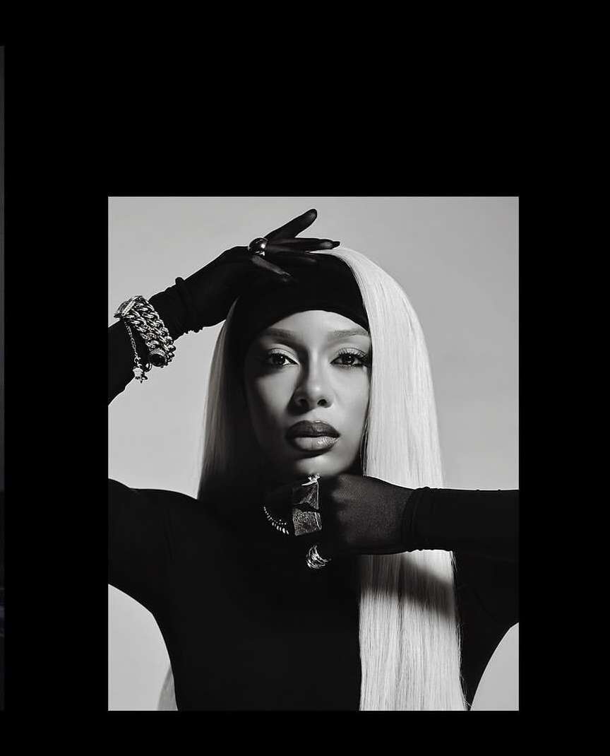 Monochrome portrait of a woman with long light hair wearing dark gloves and jewelry by Erik Carter.