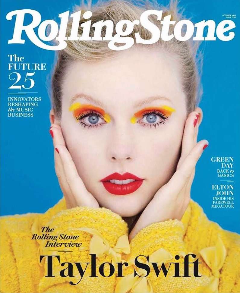 Rolling Stone magazine cover featuring Taylor Swift with bold makeup and a yellow textured sweater against a blue backdrop. Portrait.