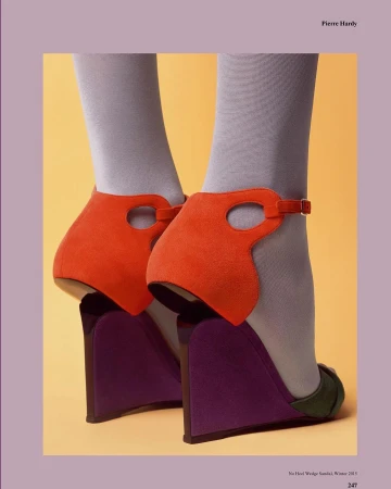 Wedge sandals by Pierre Hardy featuring an orange suede upper, purple wedge heel, and grey hosiery against a yellow background.