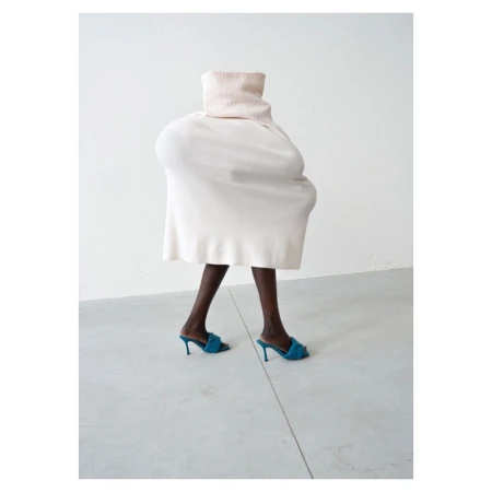 Surreal fashion portrait by Erwin Wurm featuring a person concealed beneath an oversized white sculptural garment wearing blue high heels