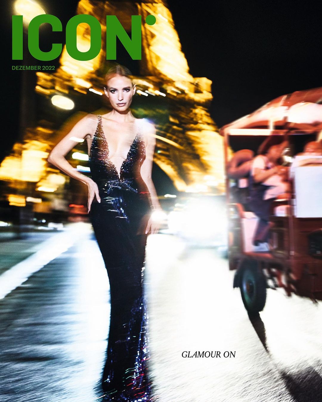 Fashion magazine cover featuring a woman in a dark gown, posing on a street in Paris at night with the Eiffel Tower in the background.