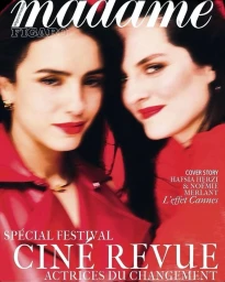 Two women with dark hair and bright red lipstick wearing vibrant red jackets against a striking red background.