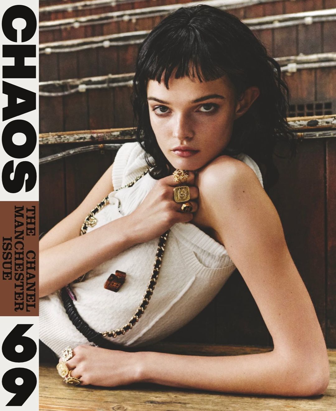 Magazine cover featuring a young woman with dark hair wearing a white top and several rings posing in front of a wooden background.